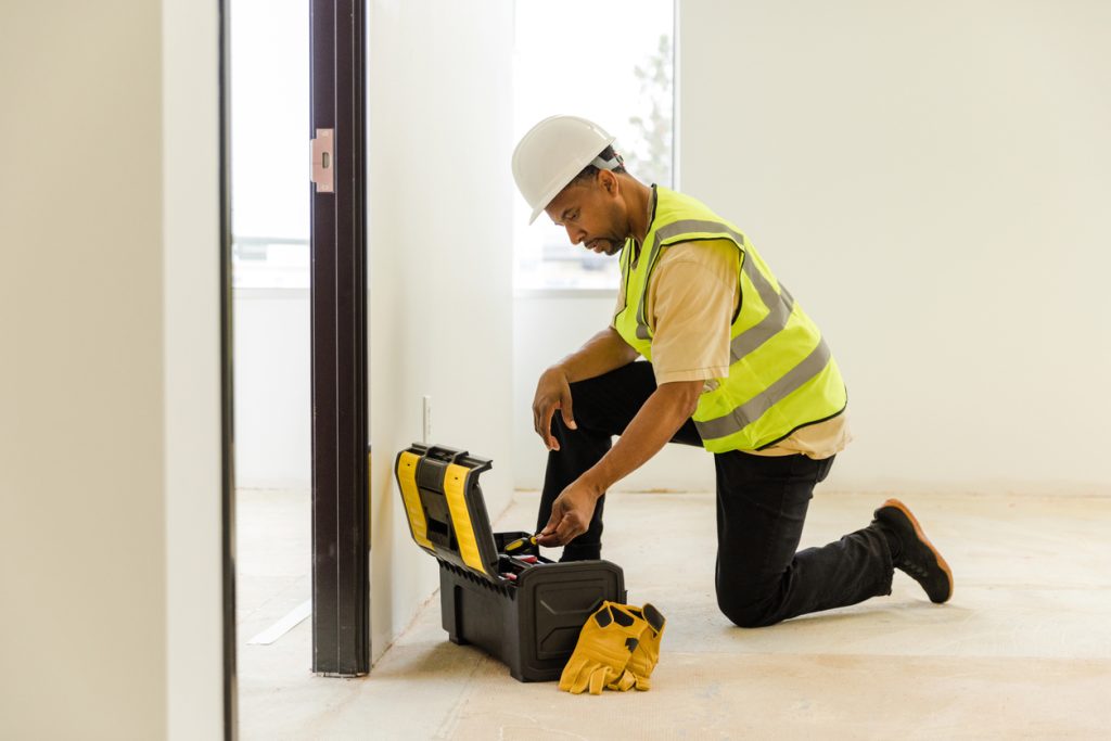 Home construction worker, on one knee while working